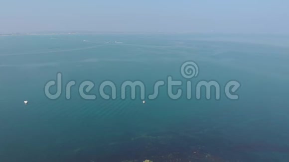 一个空中向后拍摄的老哈利岩石与水晶蓝色的水沿美丽的白色悬崖游客和船下视频的预览图