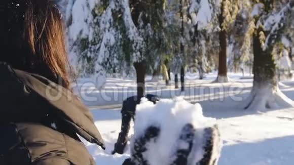 在冬天的森林里打雪仗和玩雪乐的快乐夫妻视频的预览图
