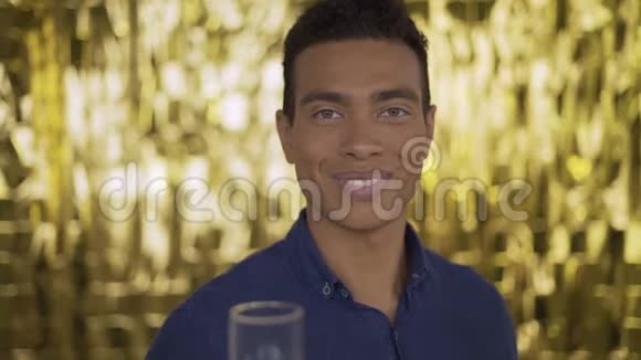 金色背景上的异国人的肖像男人微笑着拿出一罐香槟视频的预览图