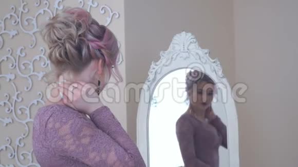 镜子前一个年轻漂亮金发女人的肖像视频的预览图