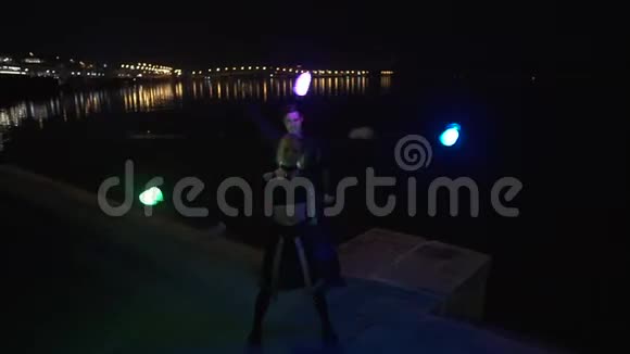 两位身材高大的艺术家在河边的夜晚用ledpoi做戏法视频的预览图