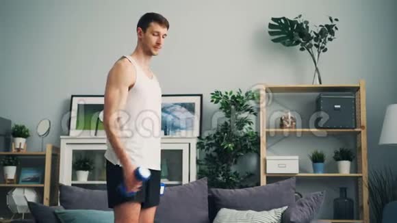 运动服健美运动员在家里独自锻炼哑铃视频的预览图