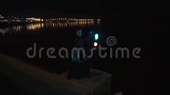 在基辅河附近的夜晚身穿忍者旋转黑色西装的艺术家带领着波伊视频的预览图