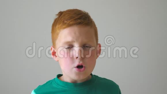 一个可爱的红发男孩抓住他的头在他的脸上表现出喜悦哈多姆的孩子很高兴视频的预览图