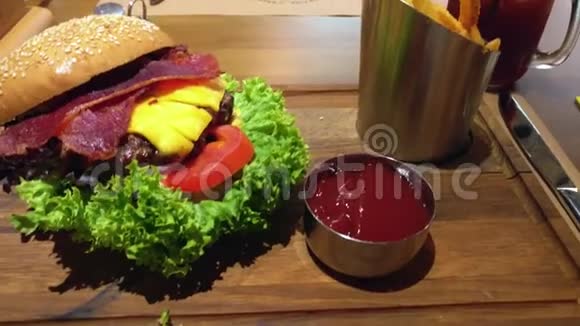 美味的开放式汉堡里面有培根奶酪西红柿和生菜旁边有番茄酱和薯条还有一种冷饮视频的预览图