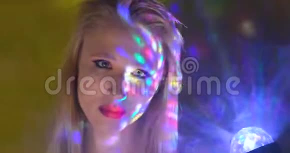 彩色灯光下跳舞的女孩的肖像视频的预览图