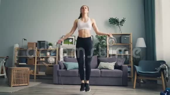 年轻女运动员在公寓里跳绳重点是有氧运动视频的预览图