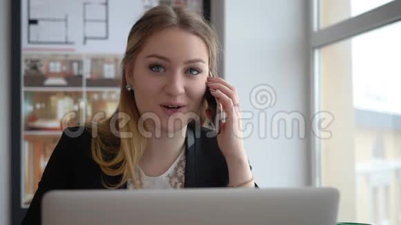幸福女建筑师在创意办公室的桌子上用手机说话视频的预览图