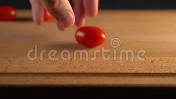 厨师把成熟的樱桃番茄切成两半放在木头表面视频的预览图