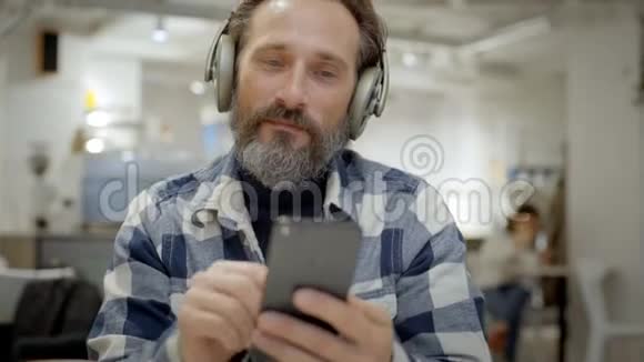 戴耳机的英俊老人的肖像视频的预览图