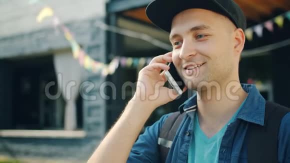 英俊的学生在街上用手机说话的肖像视频的预览图