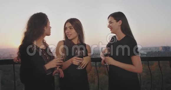 聚会时间在阁楼阳台上女士们喝着酒聊天在夕阳下秋天有着美丽的背景视频的预览图