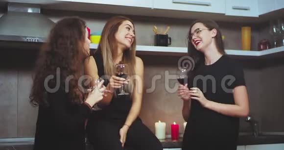 在厨房里带着酒杯的女士们在一起玩得很开心聊天拿着红酒杯戴着视频的预览图
