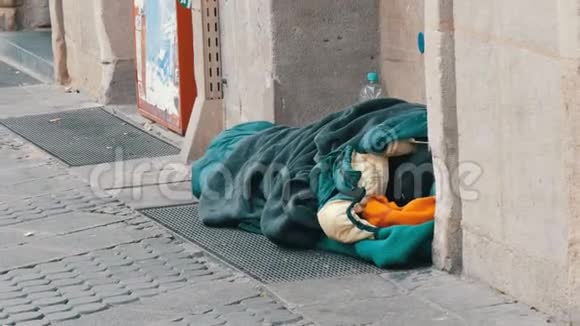 德国纽伦堡2019年12月10日一个无家可归的可怜的乞丐躺在地上睡袋要求施舍视频的预览图