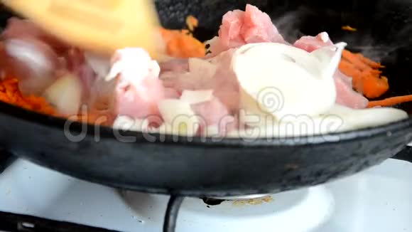 在煎锅里做饭工作室照明女孩在锅里炒猪肉牛肉和蔬菜视频的预览图