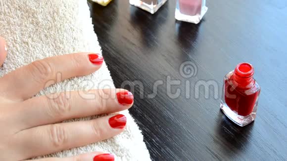 美甲美丽的美甲女性指甲用红色指甲油在柔软的白色毛巾上红色和珠光清漆视频的预览图