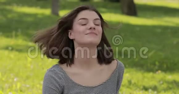 公园里微笑快乐的年轻女子抛头露面的肖像视频的预览图