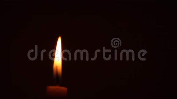 在黑色背景上隔离散焦蜡烛火焰的特写视频的预览图