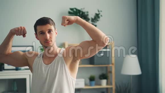 在家中肌肉发达的英俊健美运动员慢动作肖像视频的预览图