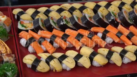 在日本传统的红色托盘背景上关闭许多寿司卷视频的预览图