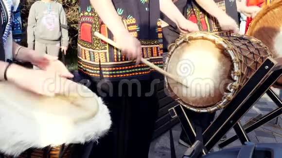 在阳光明媚的城市街道上演奏koradjembe或jembe鼓的音乐家小组视频的预览图