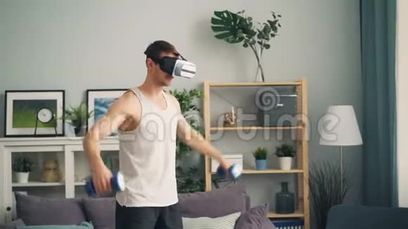 现代男运动员在家里独自戴着戴着眼镜的哑铃训练视频的预览图