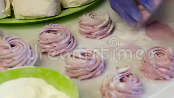 一个女人把两半棉花糖连接起来用葡萄糖处理它准备好的甜点摆在桌子上视频的预览图
