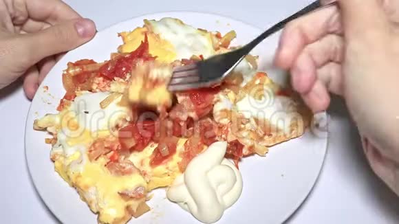 女人吃煎蛋卷炒鸡蛋配上炒西红柿和洋葱视频的预览图