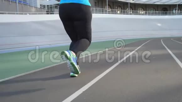 体育场跑道上超重妇女慢跑者的腿视频的预览图