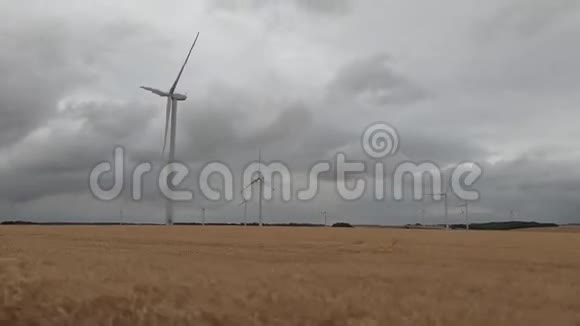 多云天气下麦田的风力涡轮机视频的预览图