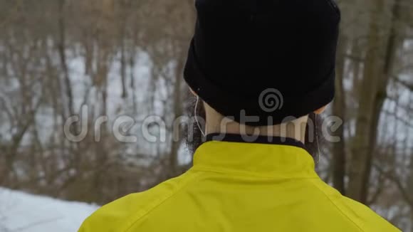 穿着运动服站在冬季森林中的人的近景视频的预览图