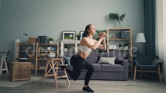 肌肉发达的年轻女人在室内做深蹲集中精力锻炼身体视频的预览图