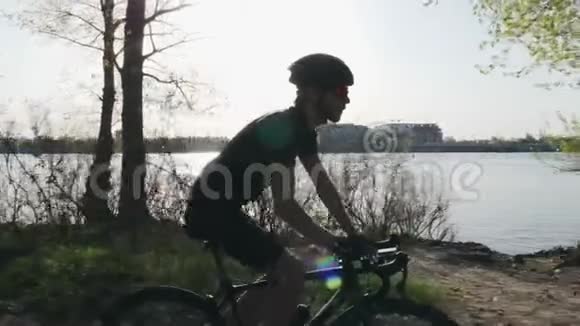 专业骑自行车的人在骑自行车的时候从比登那里喝水河流和城市背景自行车的概念慢动作视频的预览图