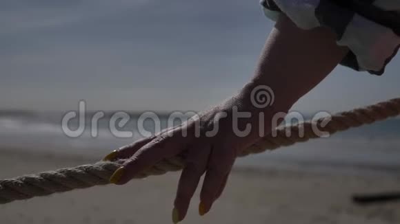 女人牵着绳子靠近大海旅行理念视频的预览图