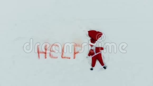 圣诞老人正在制作一个雪天使躺在附近帮助留言视频的预览图