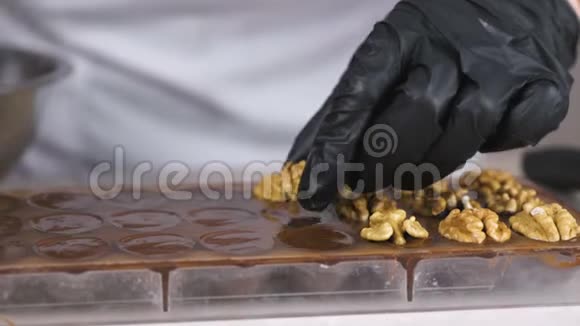 贝克双手把核桃的一半放在巧克力糖果上视频的预览图