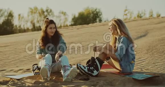 两个女孩在沙漠里系着沙盘坐骑视频的预览图