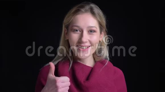 一个漂亮的高加索女性微笑的特写镜头在看镜头的时候竖起大拇指视频的预览图