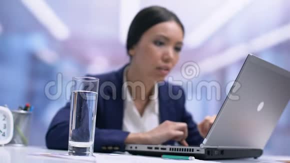 忙碌的女员工从坐在办公室的玻璃桌上喝水喝茶视频的预览图