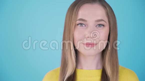 特写肖像蓝色背景的女孩有趣的女孩微笑有趣孤立的背景左4K刻字处视频的预览图