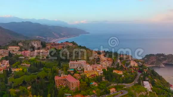 陶尔米纳是意大利西西里岛上的一个城镇傍晚从高空俯瞰在山脚下发脾气视频的预览图