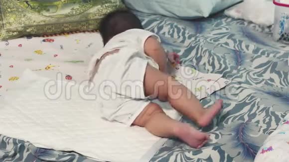 亚洲女婴躺在床上学习从背部滚到胃视频的预览图
