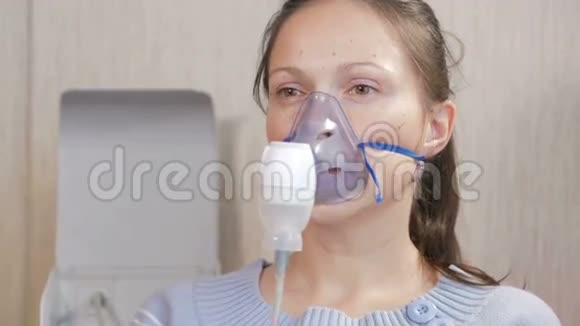 在家拿着吸入器的面罩的年轻女人通过雾化器治疗气道炎症预防哮喘视频的预览图