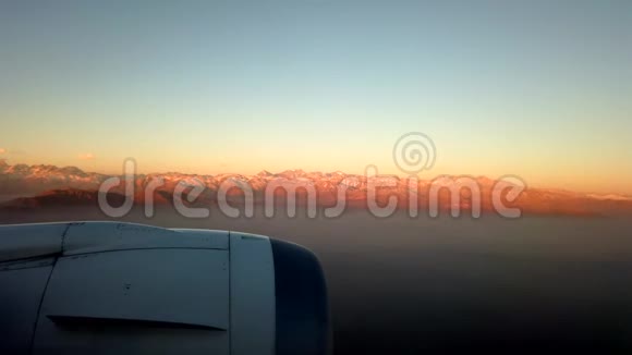 飞机窗云层下面远处有日落山视频的预览图