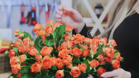 花商从花束中取出一朵橙玫瑰视频的预览图