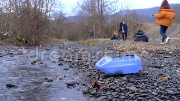 环境问题志愿者收集河岸上的垃圾视频的预览图
