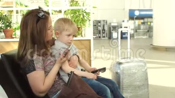 妈妈和儿子在候机室的机场打电话自拍视频的预览图