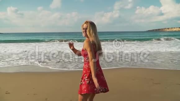 穿着黑色裤子和白色T恤的男人和穿着红色裙子的女朋友鲜花跑进大海或海洋慢慢视频的预览图