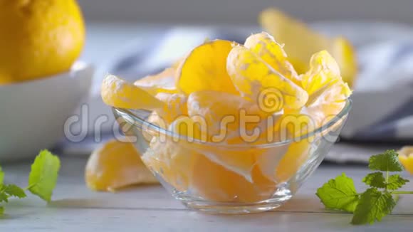 新鲜成熟的橘子和香草梅丽莎在玻璃碗在木桌上视频镜头4K50fps视频的预览图