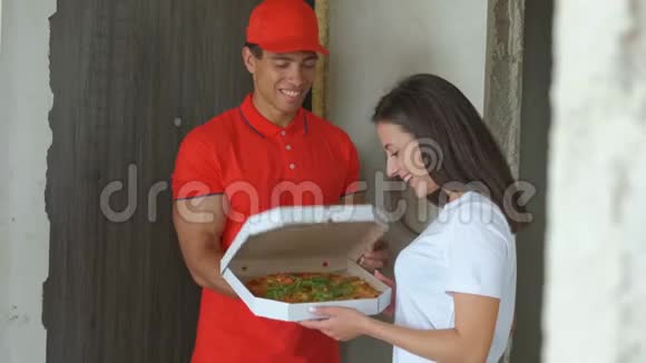年轻英俊的披萨外卖男孩漂亮女孩有披萨概念传递食品视频的预览图